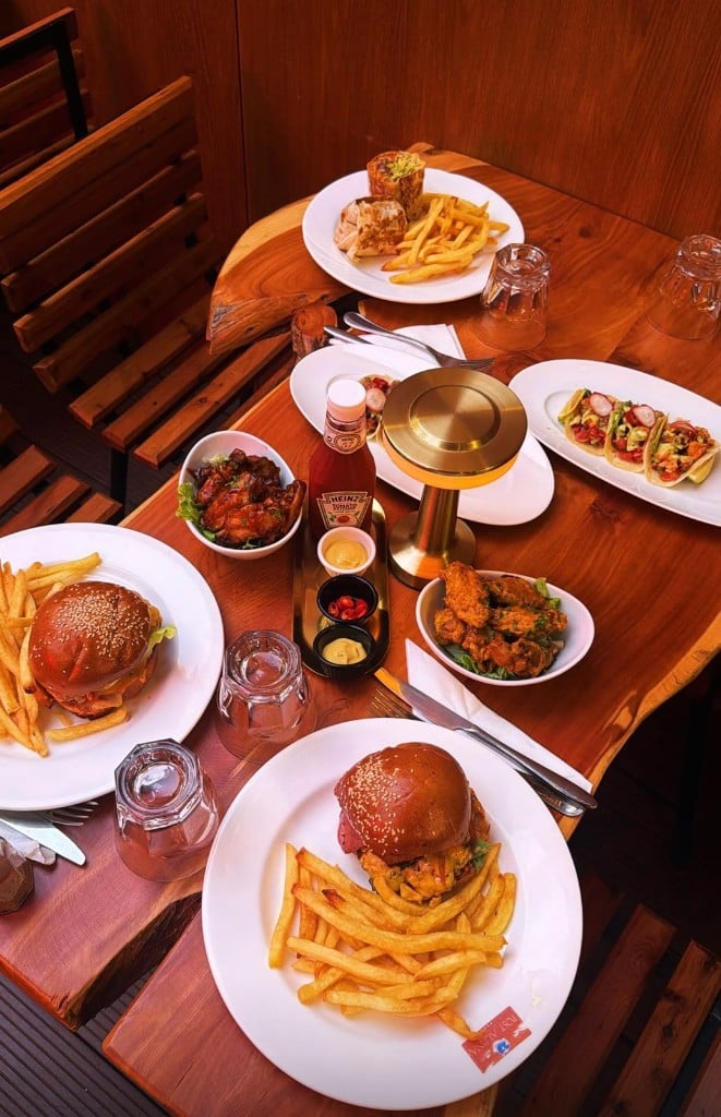 Une table de burgers, frites, ailes de poulet et tacos